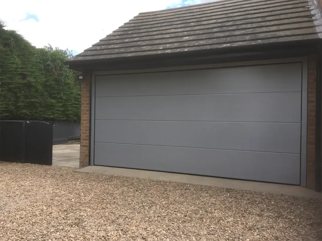 Aluminium insulated double sectional garage door on a modern home with a sleek grey finish and glazed panels