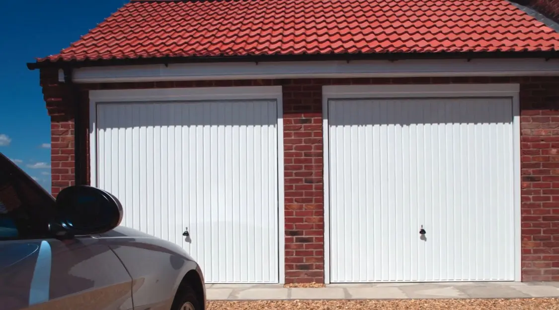 Garador twin up-and-over garage door in a classic white finish with glazed windows