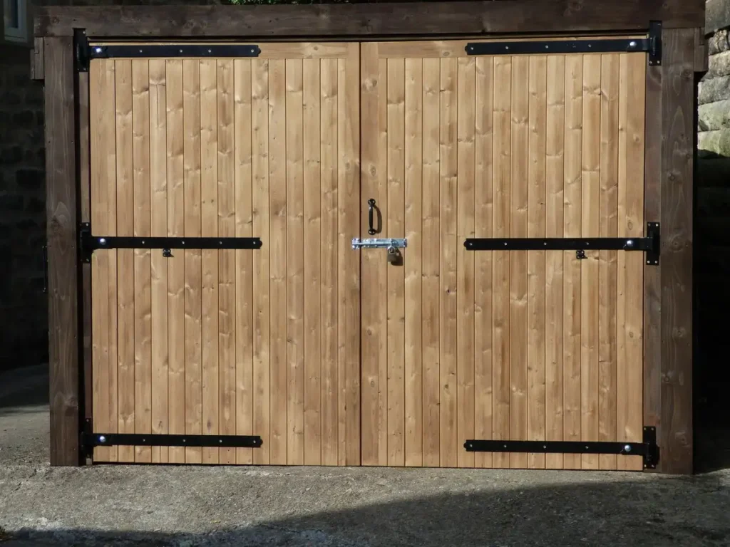 Heavy-duty timber side-hinged garage door on a residential property with reinforced hinges and a sturdy wood finish