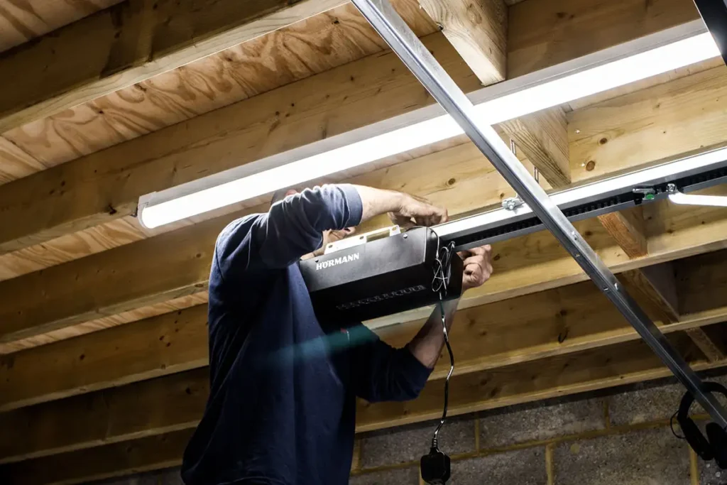 Installing a garage door automation system with the motor unit being fitted to the ceiling above the garage door opening
