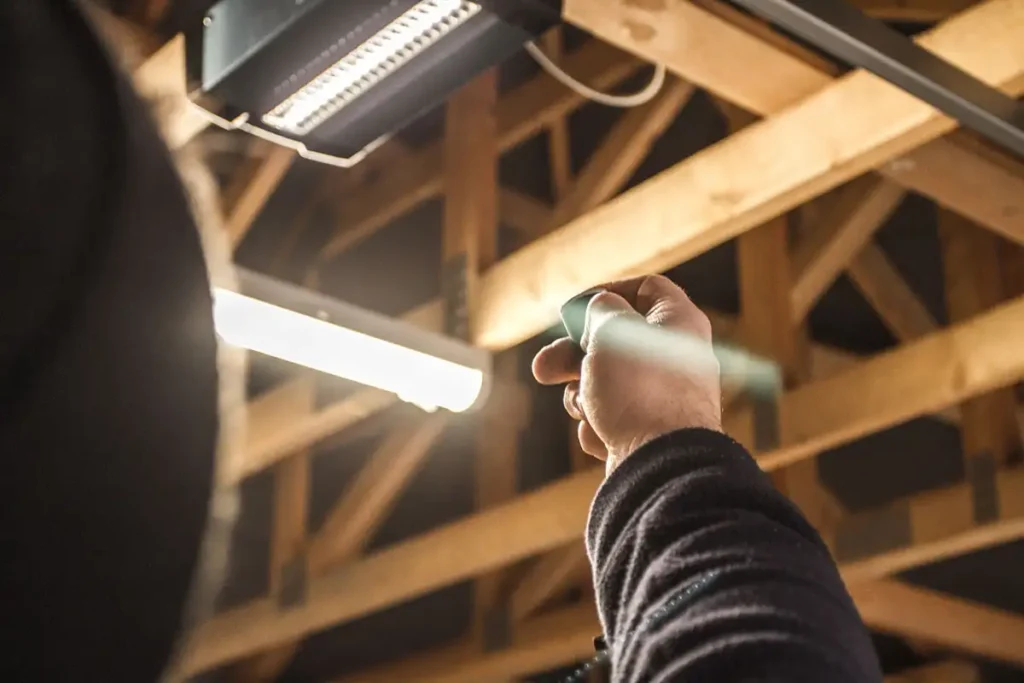 Remote control operation for garage door automation showing a handheld remote and wall-mounted control button