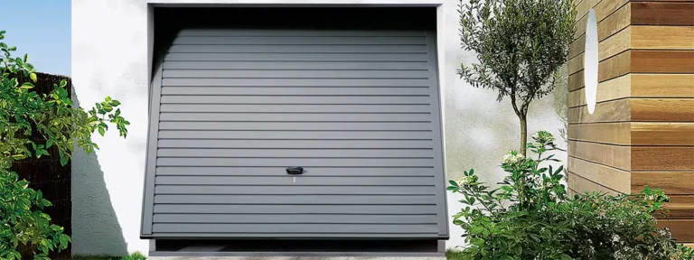 Single steel grey up-and-over garage door on a residential property with a classic panelled design