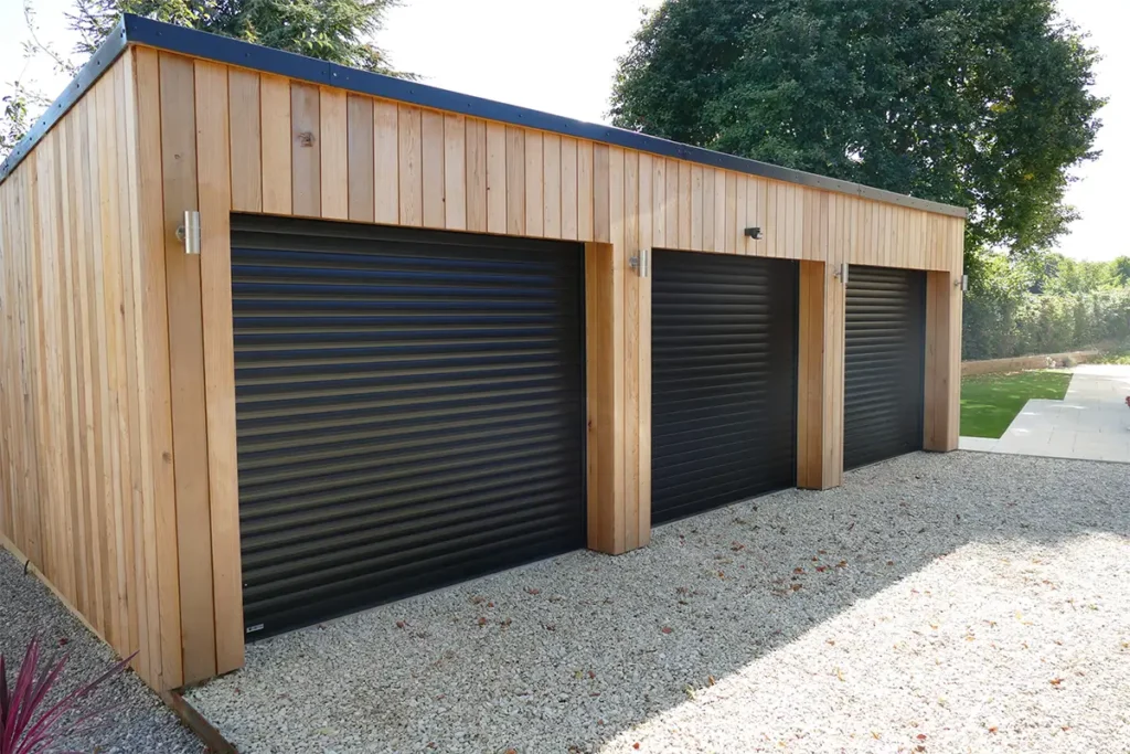 Triple single black roller garage doors on a modern residential property with a sleek, contemporary finish and independent access for three vehicles