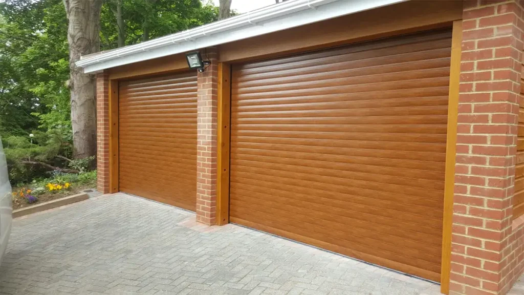 Twin single brown roller garage doors with wooden edging on a residential property, combining modern roller functionality with natural timber accents