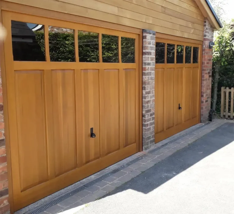 Twin up-and-over timber garage door on a residential property with a warm wood finish and traditional panelled design